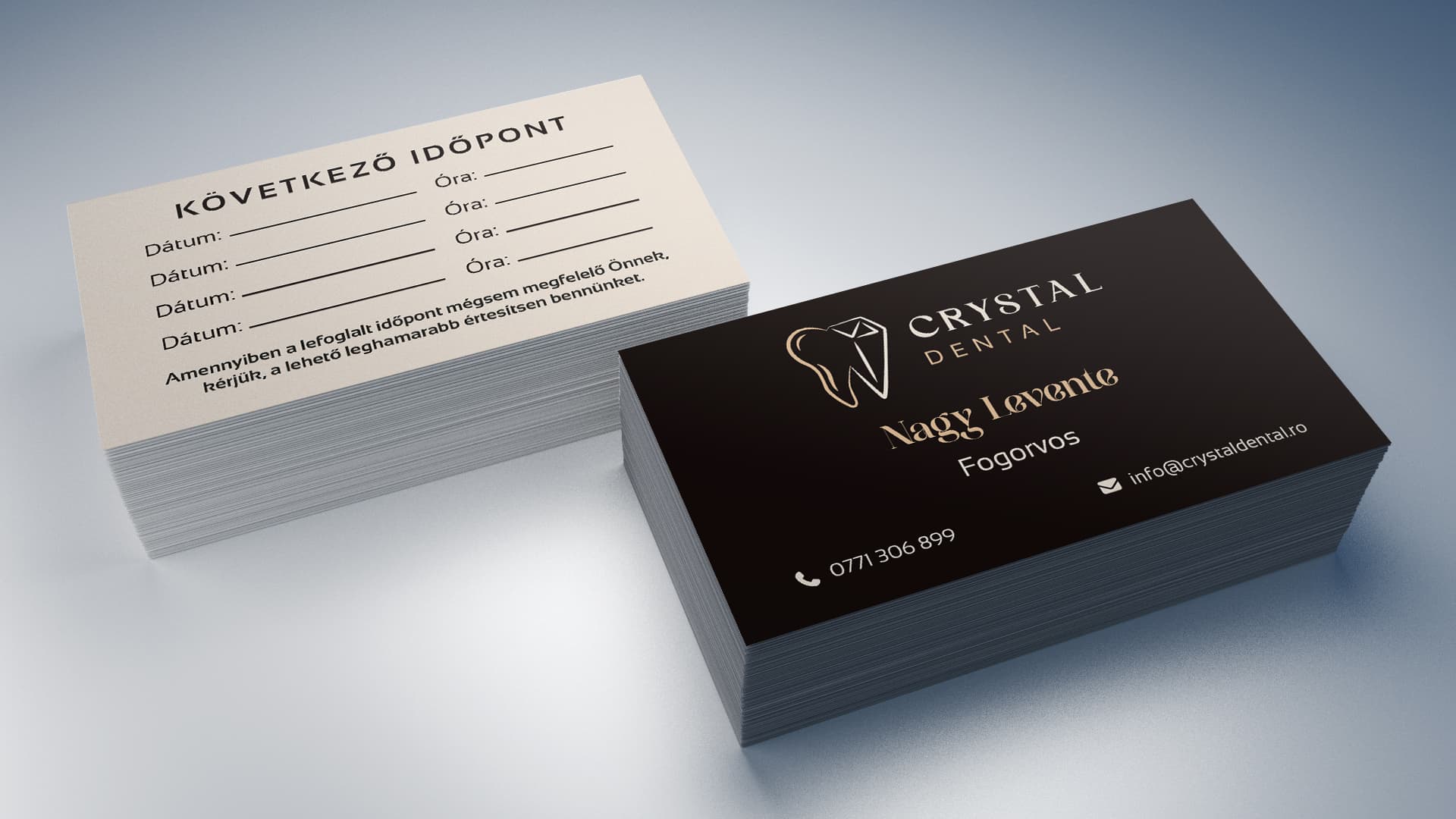 A Crystal Dental névjegykártya két oldala: fekete előlap arany logóval, krém hátlap időpont-rovatokkal